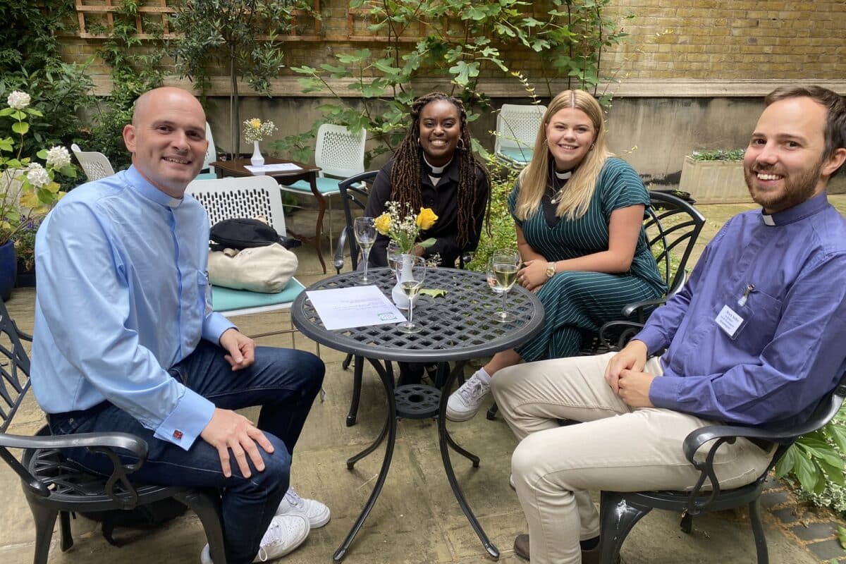 Clergy sitting at a table smiling