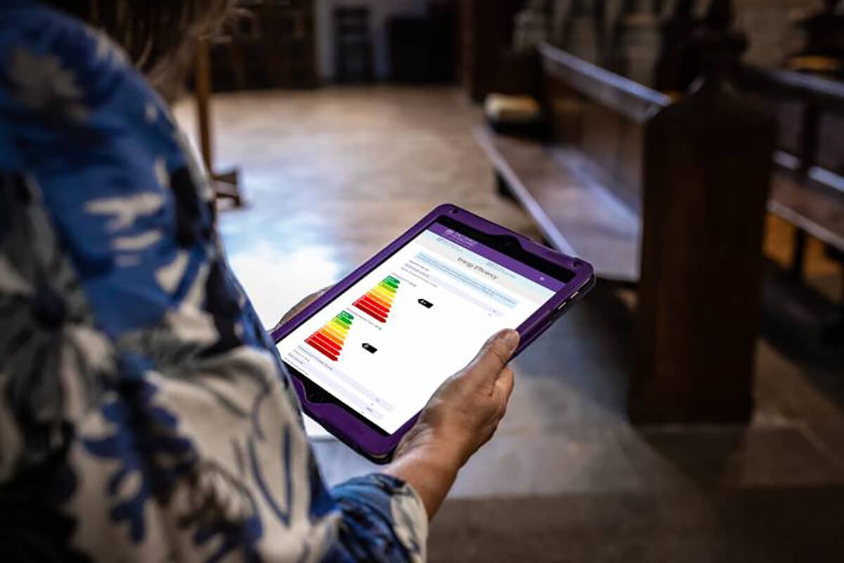 Hands holding a tablet showing energy charts
