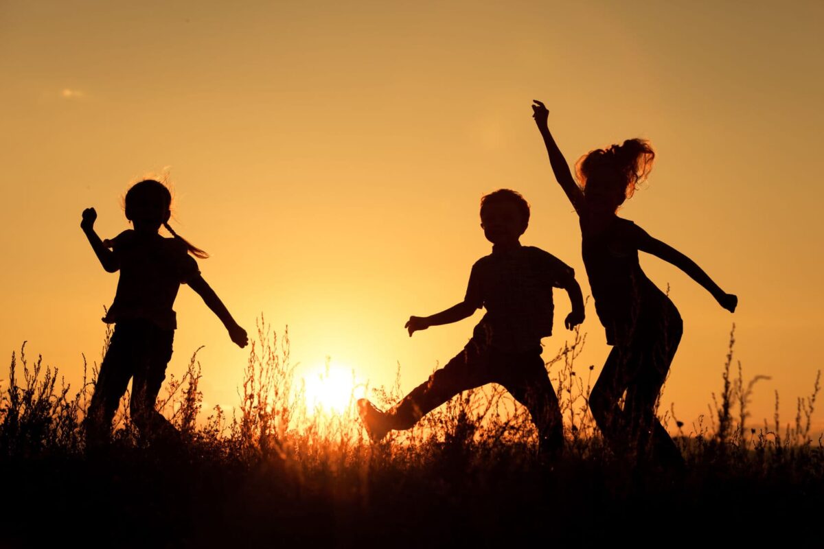 Children playing in the park at sunset