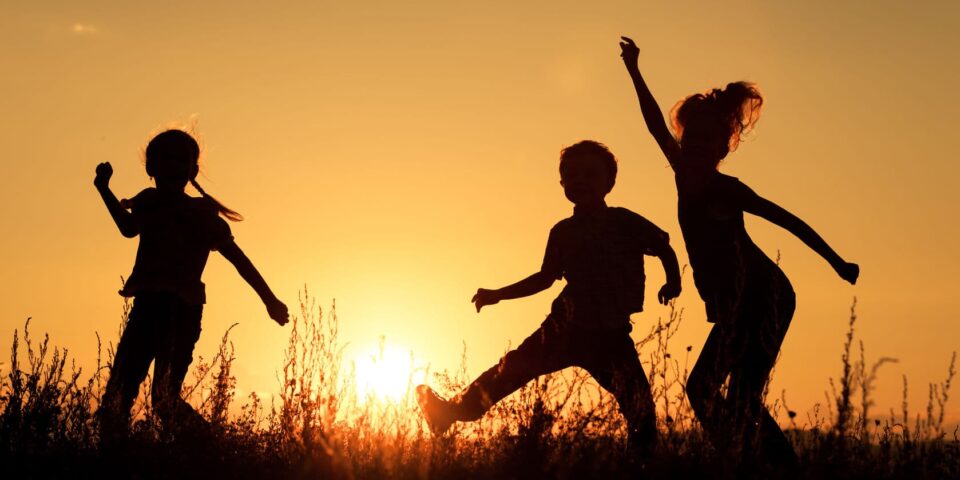 Children playing in the park at sunset