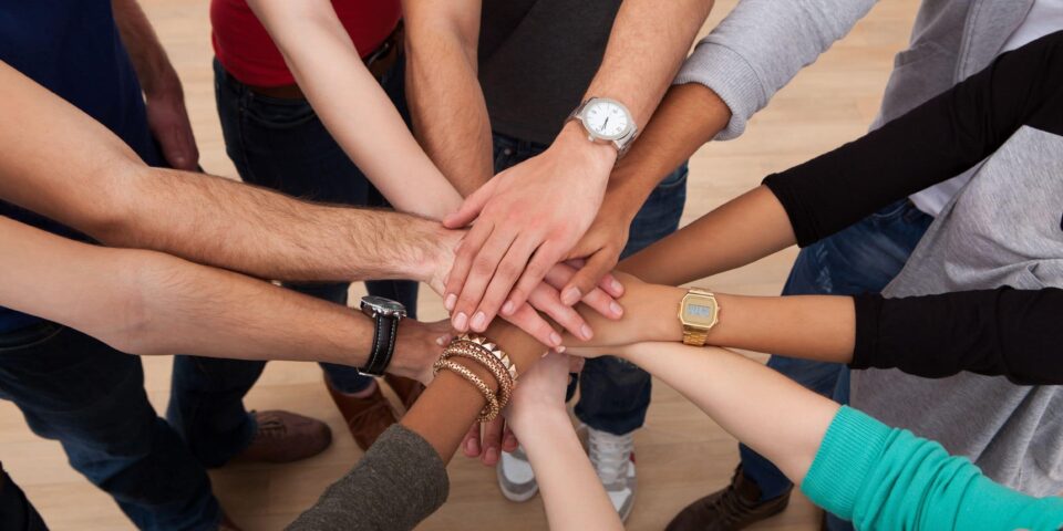College-age students stacking hands