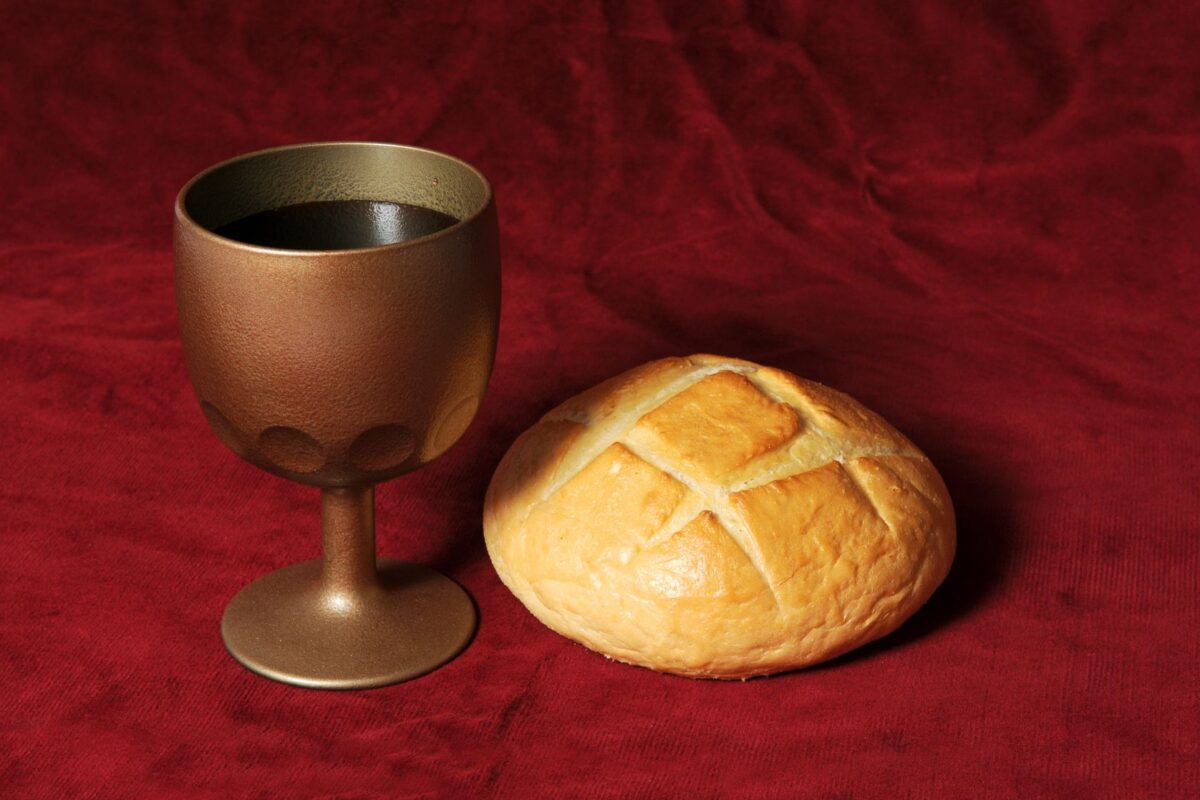 Communion elements represented by bread and wine over a red background