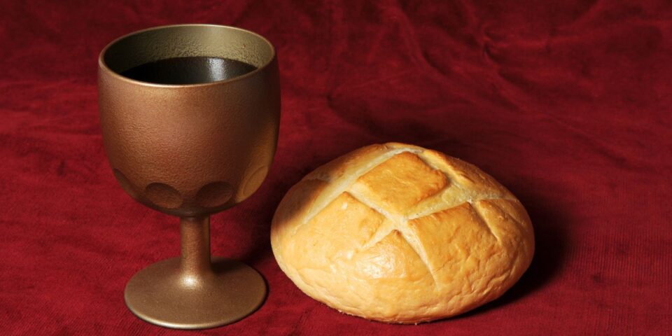 Communion elements represented by bread and wine over a red background