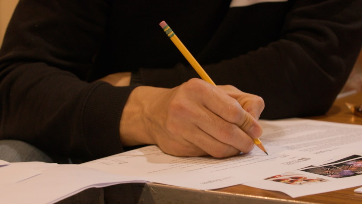 Image of hand filling in forms