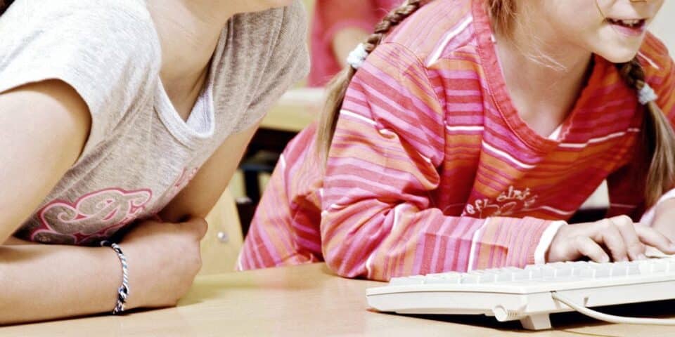 Girls smiling while paying attention in a classroom