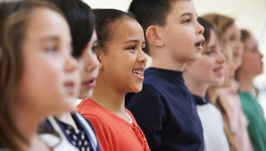 Group of school children singing together in a choir