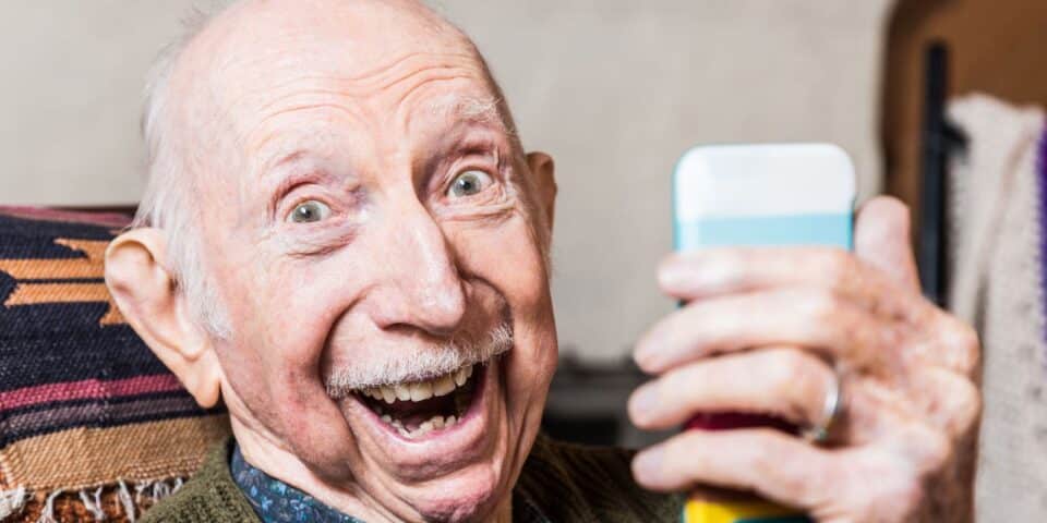 Older man taking a selfie with a smartphone