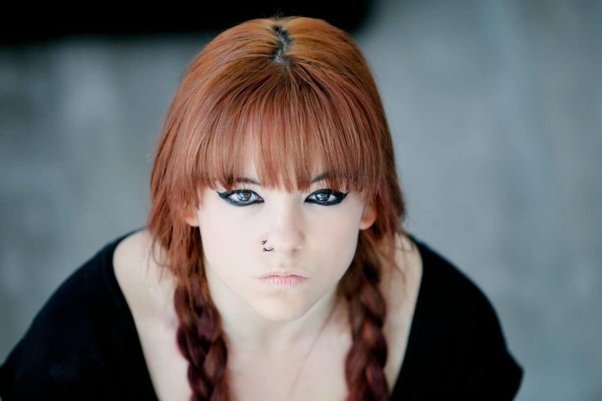 Rebellious teenager girl with red hair looking very angry