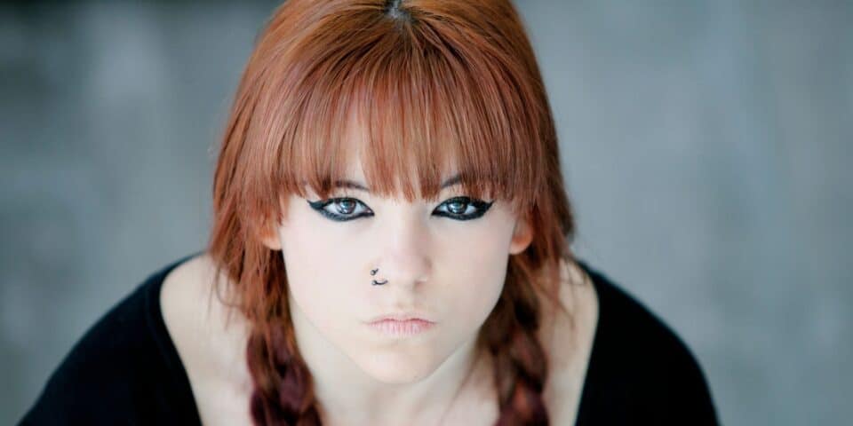 Rebellious teenager girl with red hair looking very angry