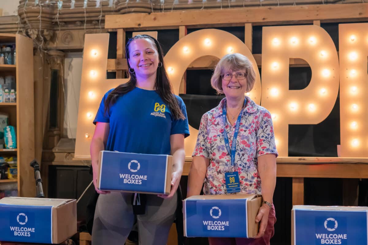 Church volunteers holding welcome boxes.