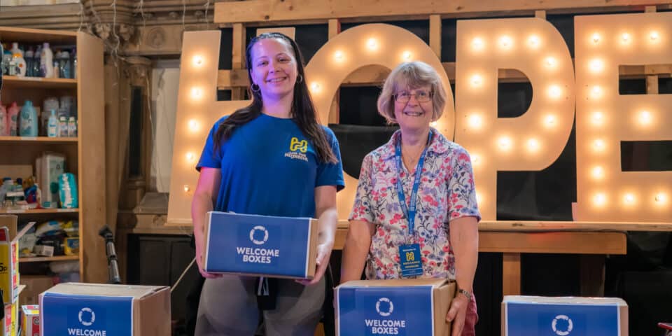 Church volunteers holding welcome boxes.