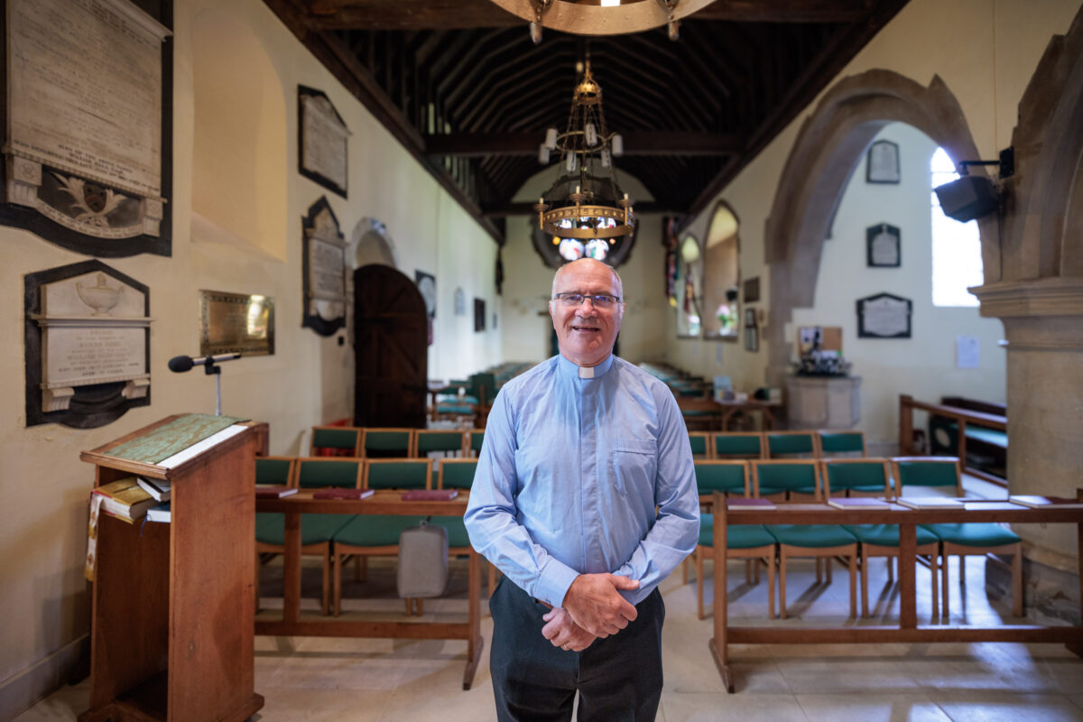 The vicar standing in the aisle of the church