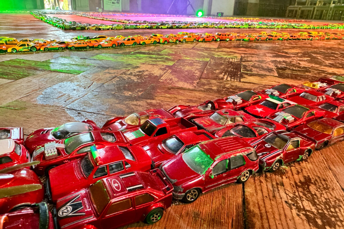 Toy cars lined up in rows to make the edges of a labyrinth