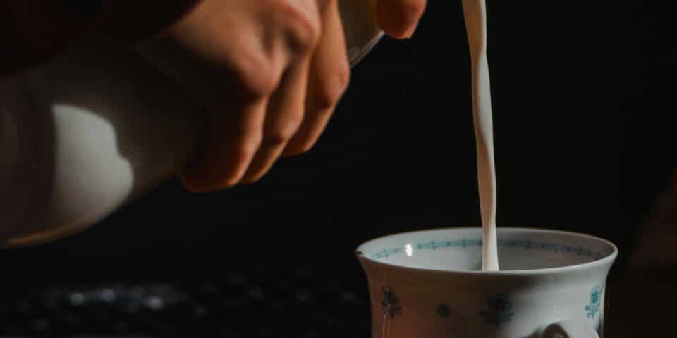 milk being poured into a mug