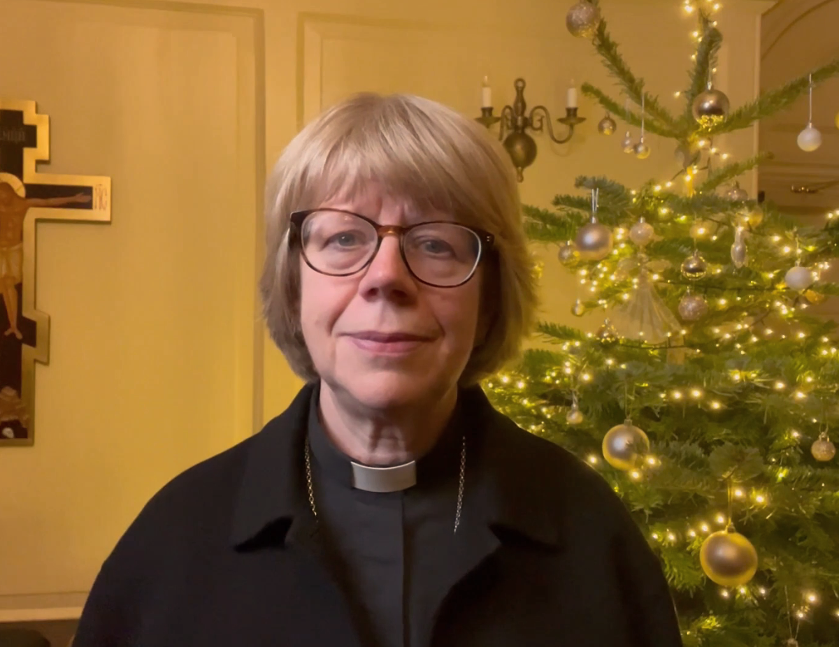 Bishop Sarah in front of a Christmas tree