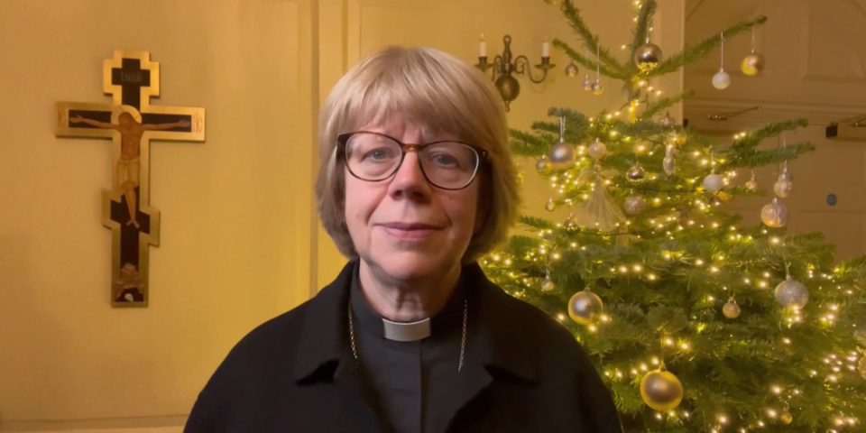 Bishop Sarah in front of a Christmas tree