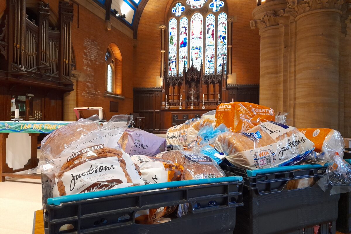 crates of bread and other groceries on a table in a church building