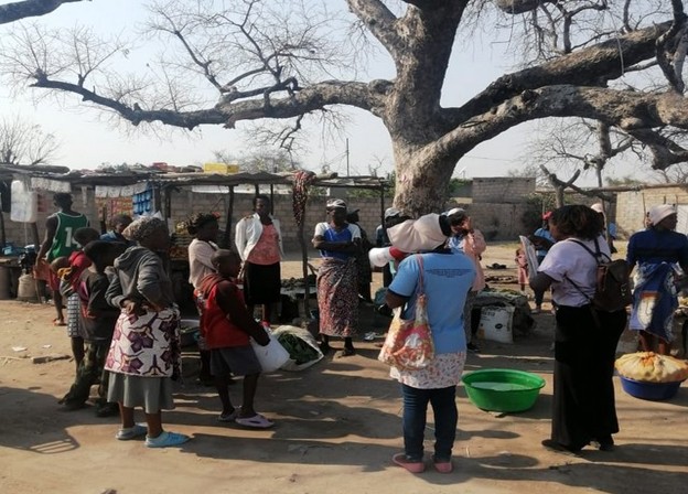 A group of people standing outside in Nampula being taught