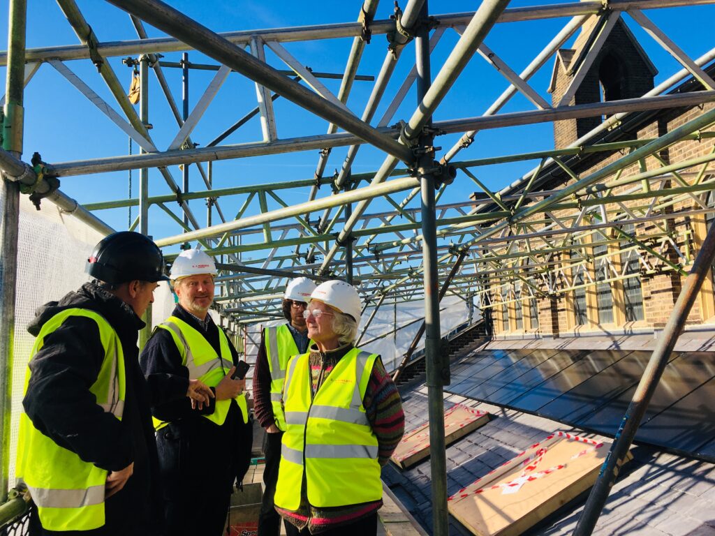 Scaffolding on top of St paul's Marylebone - a gathering of people with hard hats and high vis jackets