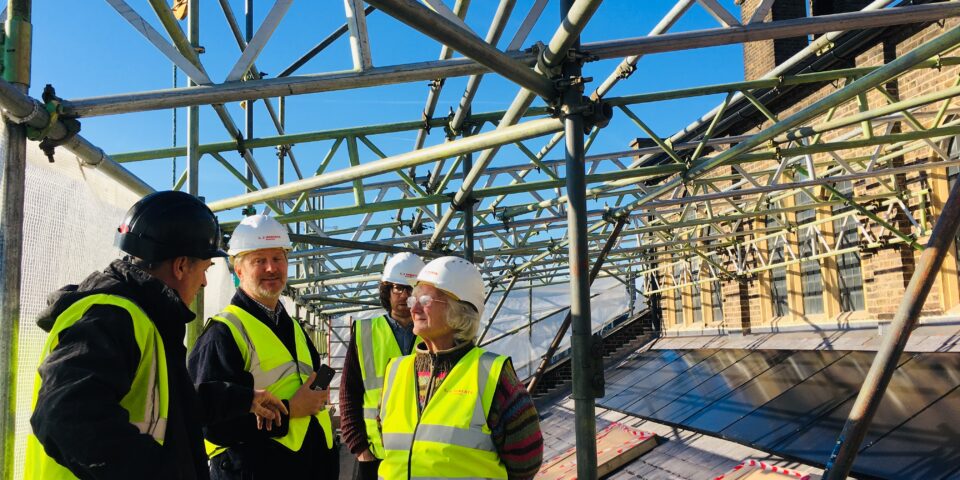 Scaffolding on top of St paul's Marylebone - a gathering of people with hard hats and high vis jackets