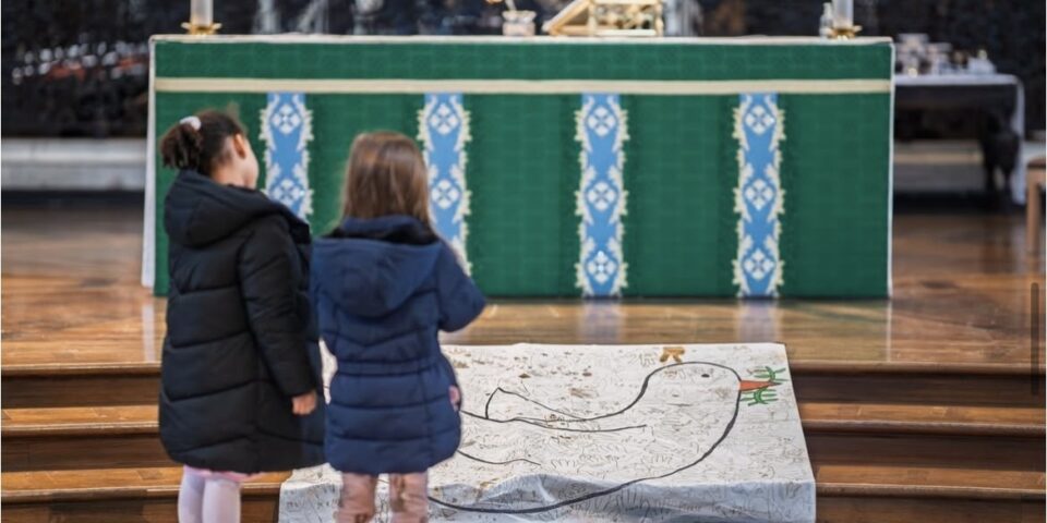 Two children standing at the alter in St Paul's cathedral, looking at a peace dove