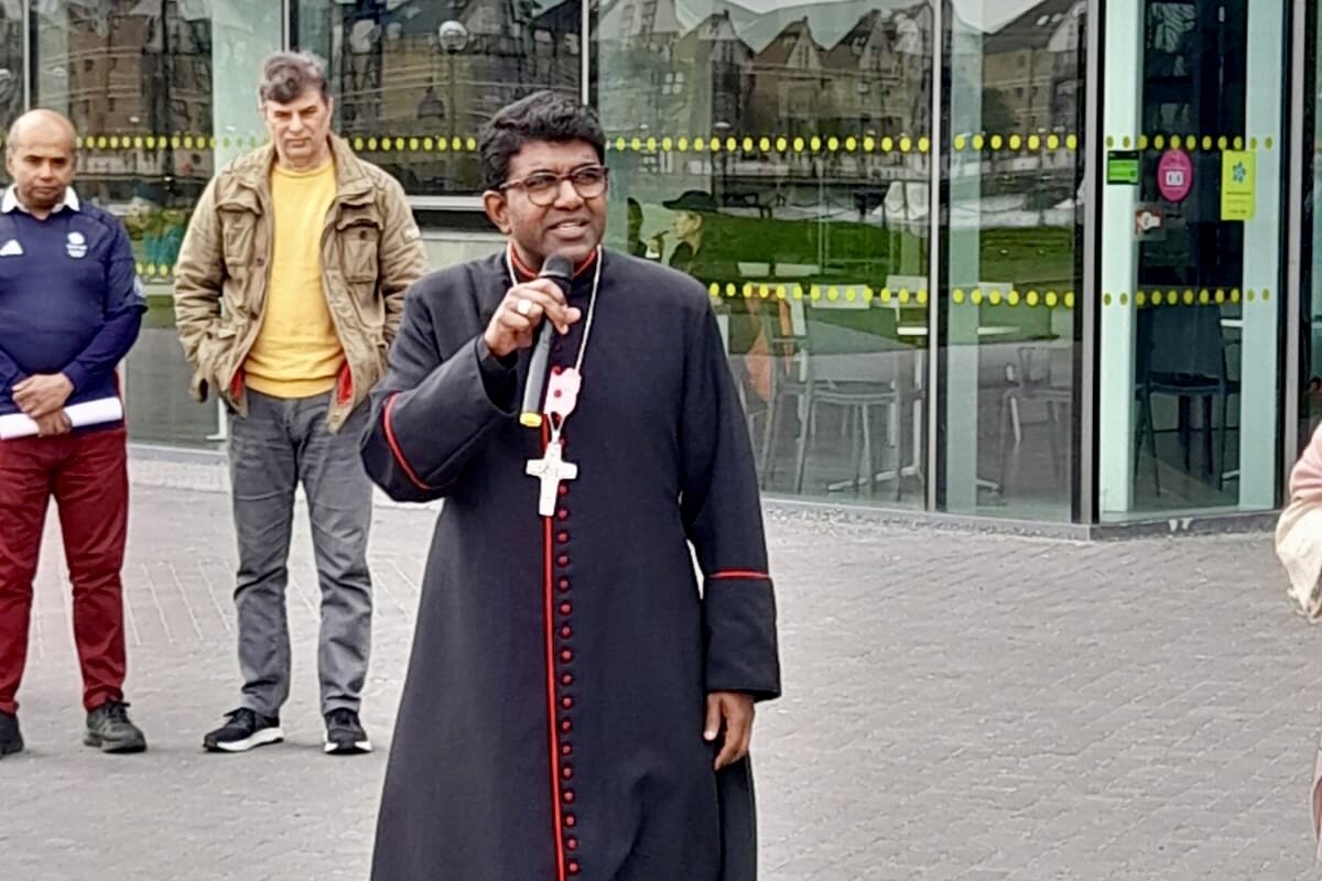Bishop Anderson speaking with a microphone outside City hall