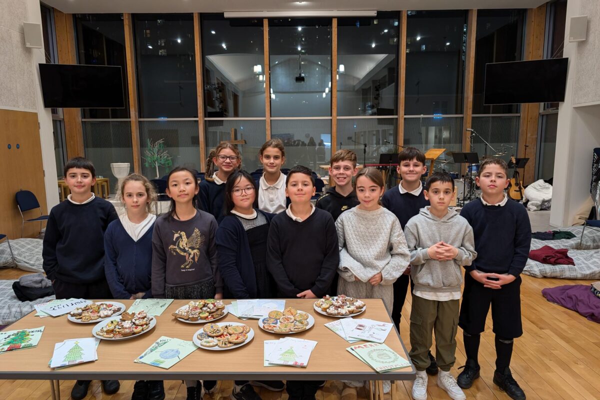 Group photo of 12 Year 6 Children standing behind a table in a church