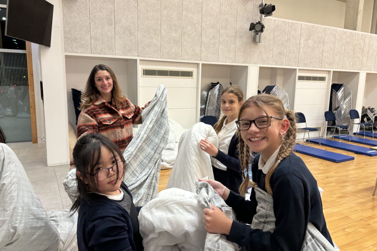 children and adults putting on duvet covers while volunteering at church night shelter