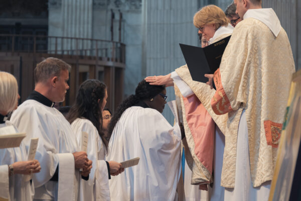 Bishop Sarah laying hands on a candidate who is being ordained as deacon