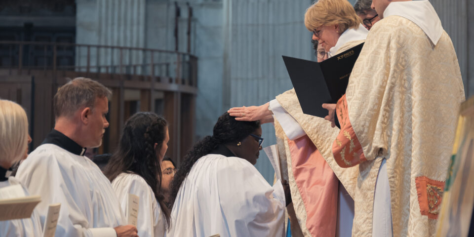 Bishop Sarah laying hands on a candidate who is being ordained as deacon