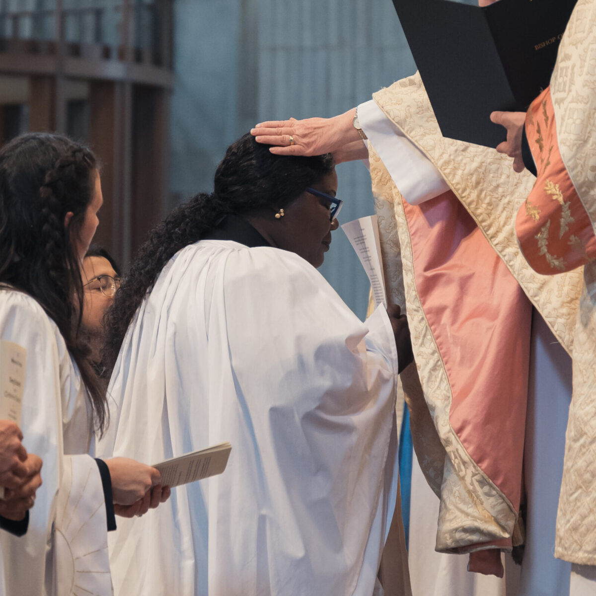 Bishop Sarah laying hands on a candidate who is being ordained as deacon