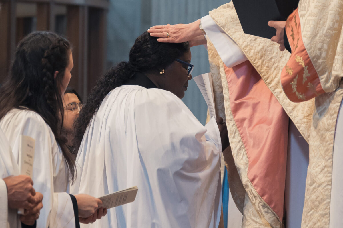 Bishop Sarah laying hands on a candidate who is being ordained as deacon