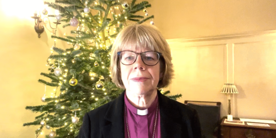 Bishop Sarah infront of Christmas tree