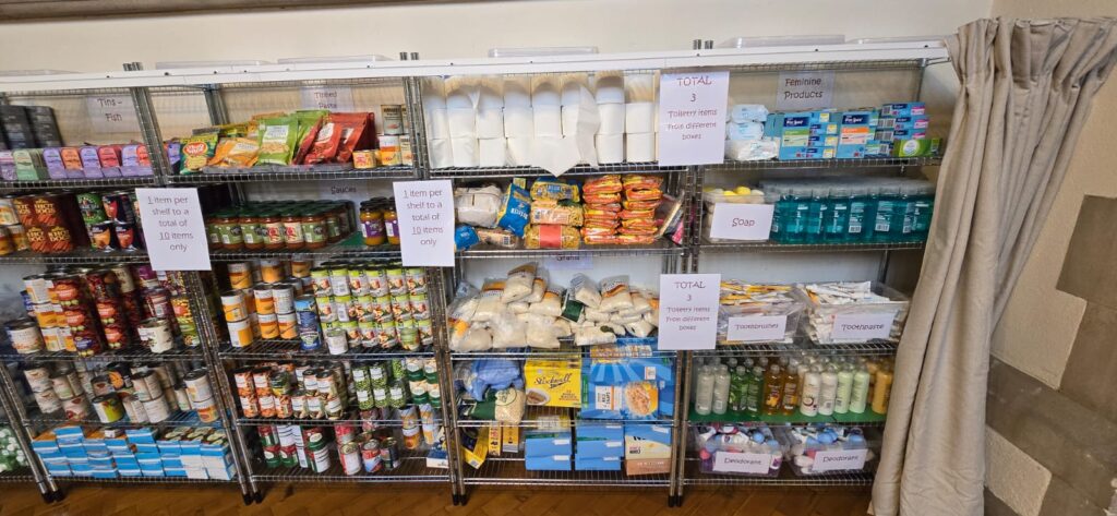 Shelves stocked with groceries at the food bank at St Matthew's Bayswater.