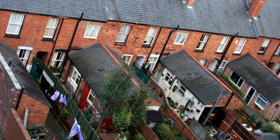 Back gardens of terraced houses in an English city.