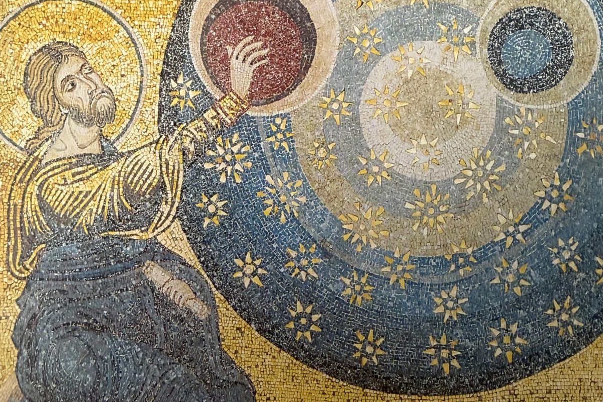 A mosaic from the cathedral of Monreale depicting christ placing the stars in the sky.